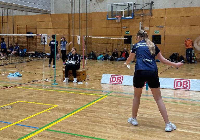 Foto einer Badmintonspielerin beim Aufschlag
