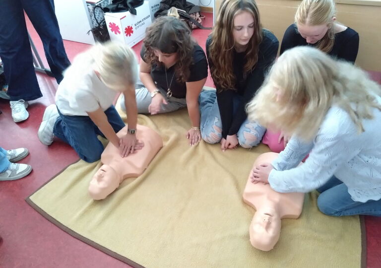 zwei Schüler reanimieren eine Puppe