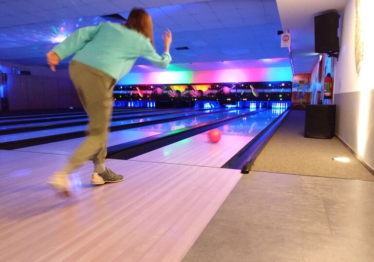 Schüler wirft eine rote Bowlingkugel