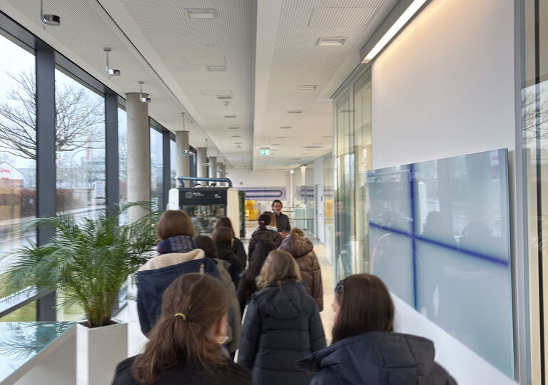 Die Schülerinnen laufen einen langen Gang entlang