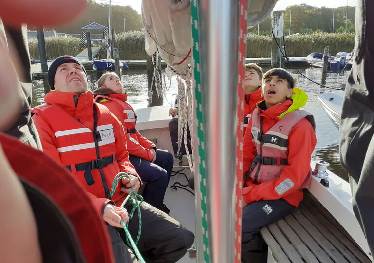 Schüler schauen am Mast nach oben