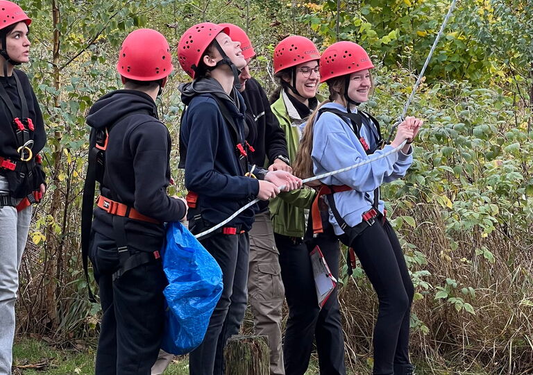 Schüler sichern kletternde Schüler