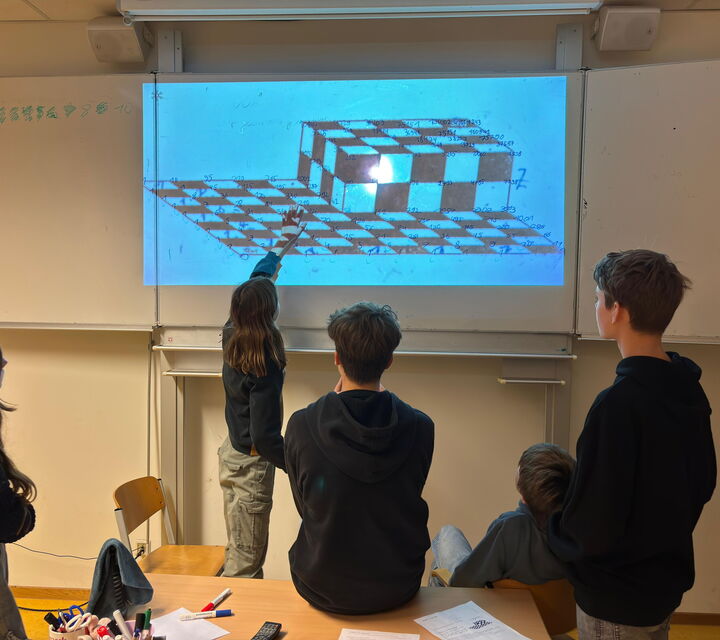 Schülern denken an einer Tafel über mathematische Probleme nach