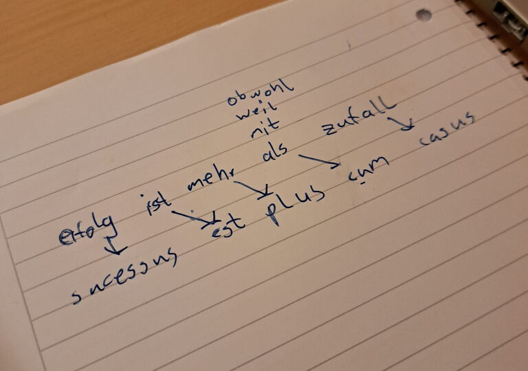 Lösungssatz auf Deutsch und Latein auf einem Block