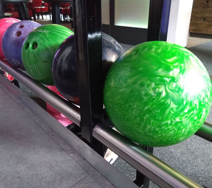 Bild mit fünf verschiedenenfarbigen Bowlingkugeln