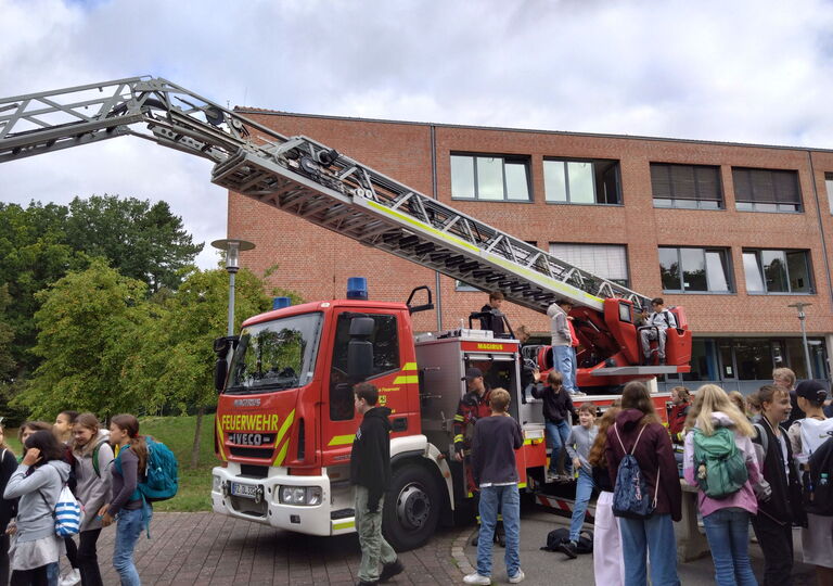 Schüler klettern auf ein Drehleiter-Fahrzeug