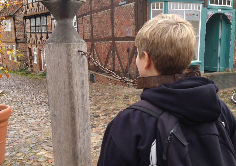 Ein Schüler steht am Pranger