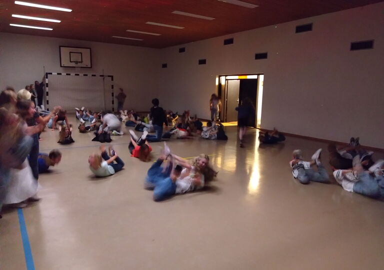 Schüler liegen auf dem Boden und tanzen den Robbentanz