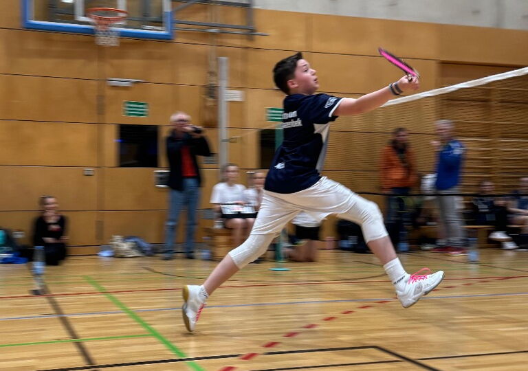Ein Badmintonspieler im Sprung