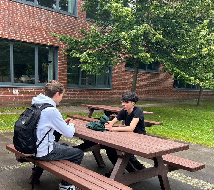 Zwei Schüler sitzen an einem Picknicktisch