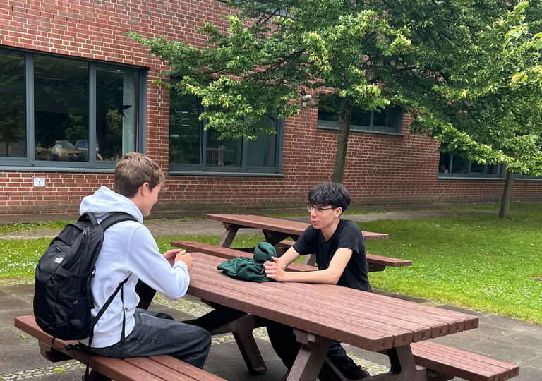 Zwei Schüler sitzen an einem Picknicktisch