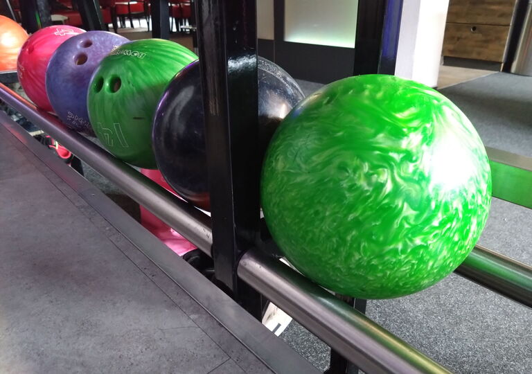 Bild mit fünf verschiedenenfarbigen Bowlingkugeln