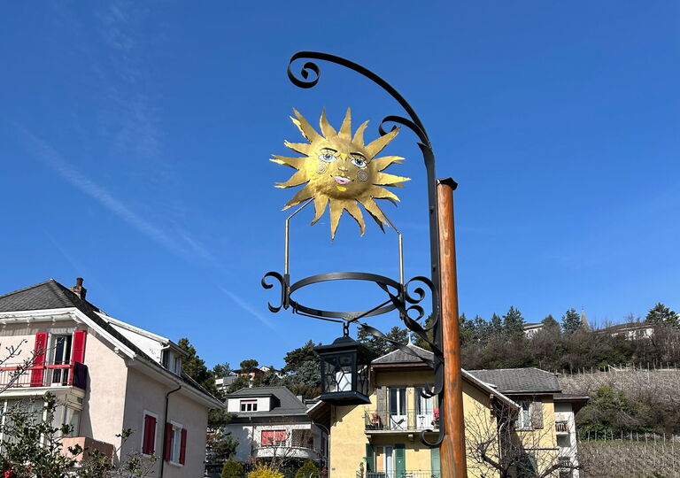 Bild einer kleinen Laterne an einem Metallstab mit einer dekorativen Sonne darüber